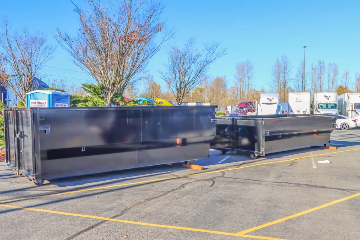 Professional dumpster rental service with roll-off container on residential driveway in Fort Polk South